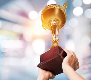 Image of hands holding trophy raised overhead