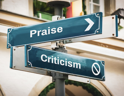 Image of street signs for Praise and Criticism pointing in different directions