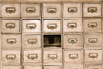 Image of a library card catalog missing a drawer