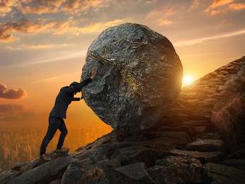 Image of a man pushing a boulder up a hill