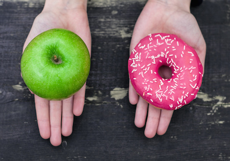 Image of two hands offering a donut or an apple