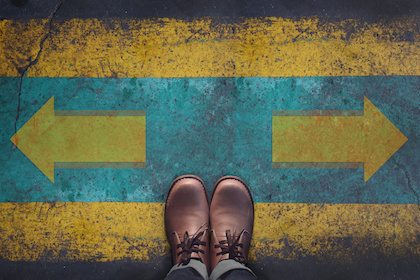 Image of shoes poised before two arrows at a Crossroad