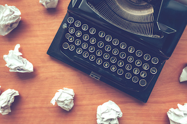 Image of typewriter surrounded by crumpled up papers