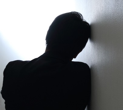 Image of worried man leaning against wall