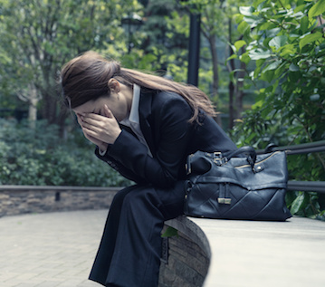 Image of woman holding her head in her hands