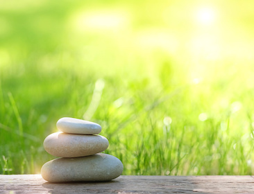 Image of three stones stacked in a beautiful garden