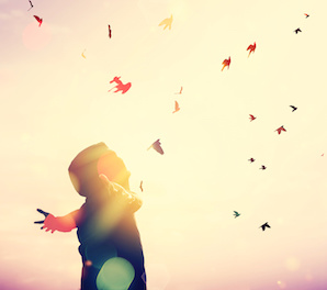 Image of a man joyously releasing birds into a sun-filled sky