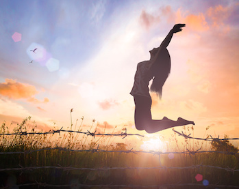 Image of woman leaping over barbed wire fence