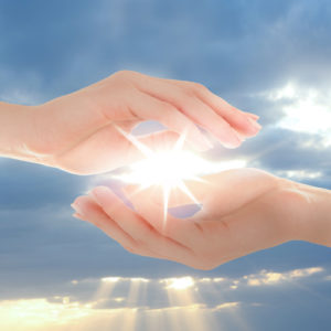 Image of Female hands holding sunlight on sky background