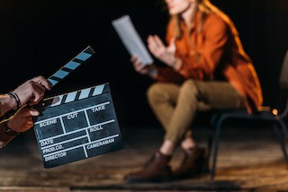 image of an actor reading from a script with a clapboard in front