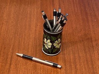 Image of Zebra F-301 pen on wood tabletop with more of the pens in a small container