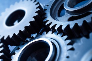 Image of engine gear wheel, for industrial background with blur effect in shades of blue-gray