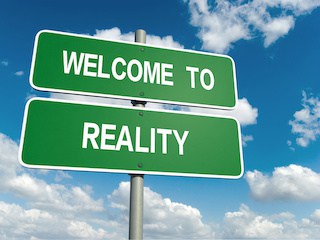 Image of highway-style sign saying "welcome to reality" against background of blue sky with clouds